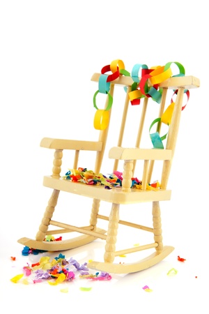 Yellow wooden rocking chair with birthday guirlandes isolated over white backgroundの写真素材