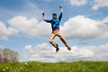 Happy jumping man outdoor in the fieldsの写真素材