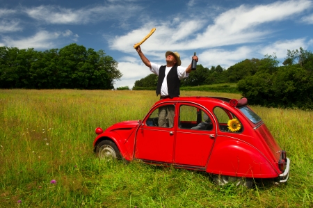 Typical French man with bread wine and his carの写真素材