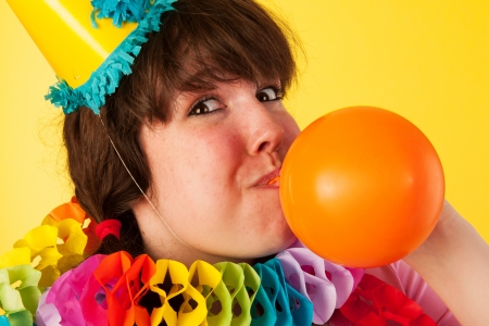 Young girl is blowing the birthday balloonの写真素材