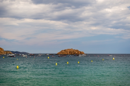 Spanish coast at Tossa de Mar with little motor boats and fishing boatsの写真素材