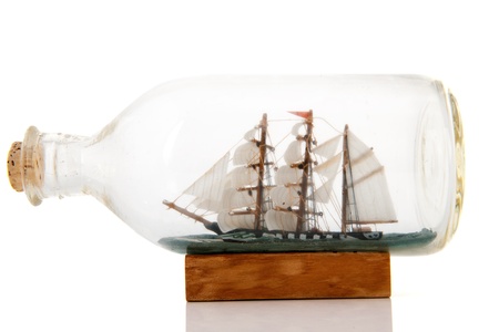 Old sailboat in glass bottle isolated over white backgroundの写真素材