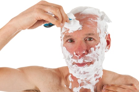 Bald man with razor and foam is shaving his headの写真素材