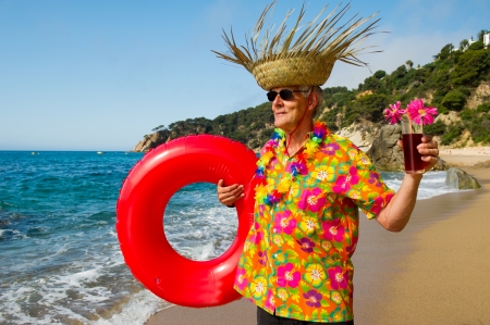 Senior man with cocktail drink at the tropical beachの写真素材