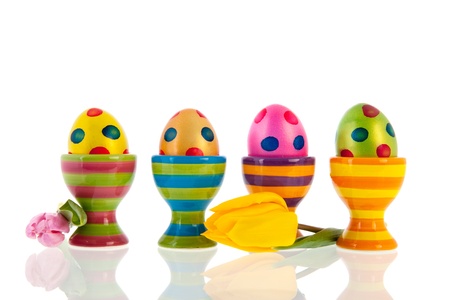 Colorful easter eggs in cups and tulips isolated over white backgroundの写真素材
