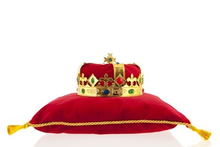 Golden crown on red velvet pillow for coronationの写真素材