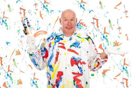 Painter with colorful paint brushes and safety mask is making a mess at the wall