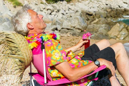 Senior man is sleeping while having vacation at the beachの写真素材