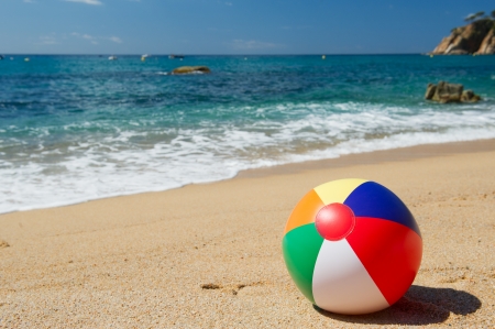 Inflatable beach ball in the sand near the water line at the Spanish beachの写真素材
