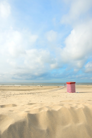 Beach of German wadden island with typical striped chair and flagの写真素材