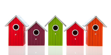 Colorful bird houses in a row isolated over white backgroundの写真素材