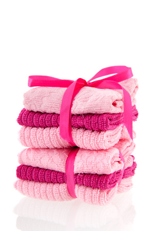 Stacked pink towels with ribbon isolated over white backgroundの写真素材