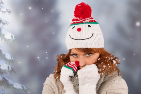 Portrait of woman in winter with snow and snowman hatの写真素材