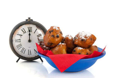 Dutch traditional oliebollen and watch on twelve o'clock isolated over white 