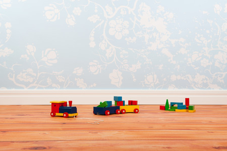 Room with blue vintage wall paper and wooden floor with old toysの写真素材