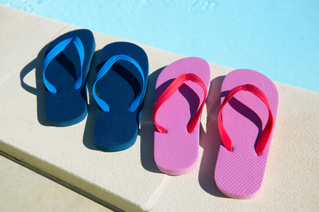 Flip flops for him and her at the swimming poolの写真素材