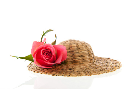 Wicker summer hat with pink rose isolated over white backgroundの写真素材
