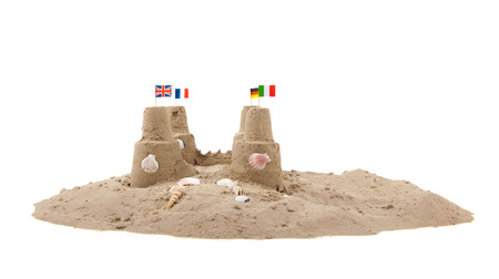 Sand castle with little flags from Europe at the beachの写真素材