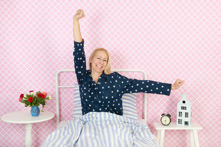 Middle aged woman waking up in the morningの写真素材