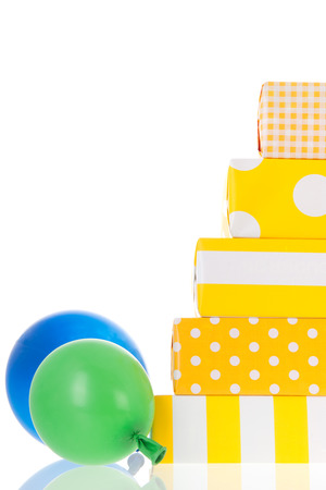 Sunny yellow wrapped gifts stacked and isolated over white backgroundの写真素材
