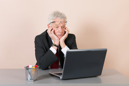 Senior man working with laptop at the officeの写真素材