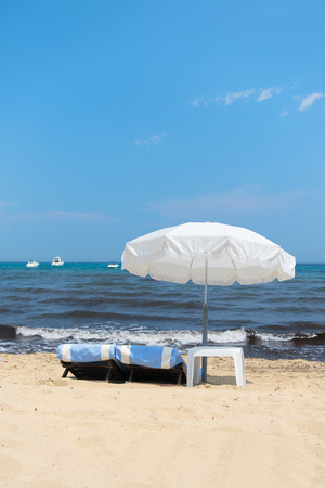 Beach with parasols, beds and luxury yachtsの写真素材
