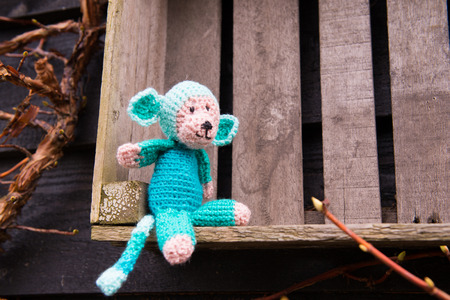 crocheted selfmade monkey toy sitting on crate outdoorの写真素材