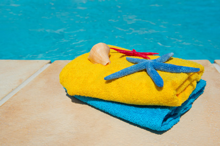 Towels in blue and yellow at the swimming poolの写真素材