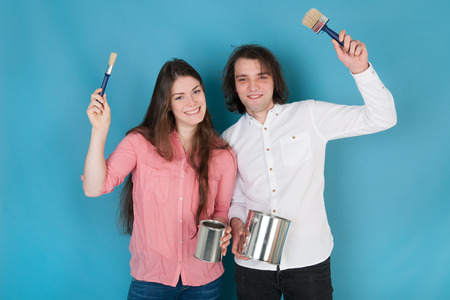 Young couple with paint and brushes in interiorの写真素材