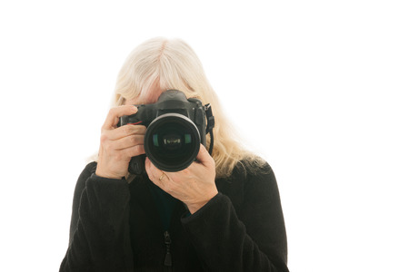 Senior woman with big photo camera isolated over white backgroundの写真素材