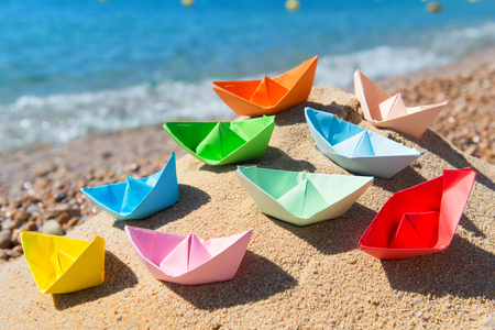 Paper boats in the sand at the beachの写真素材