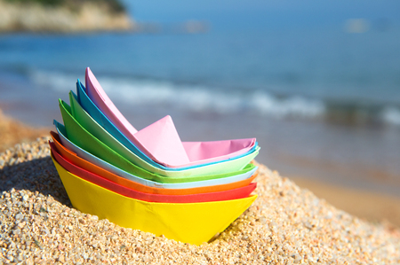 Stacked paper boats at the beach to play withの写真素材