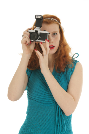 Portrait attractive woman with red hairas tourist with photo camera isolated over white backgroundの写真素材