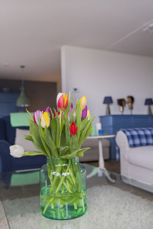 Colorful vase with bouquet tulips in interiorの写真素材