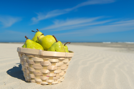 Basket fresh pears at the beachの写真素材