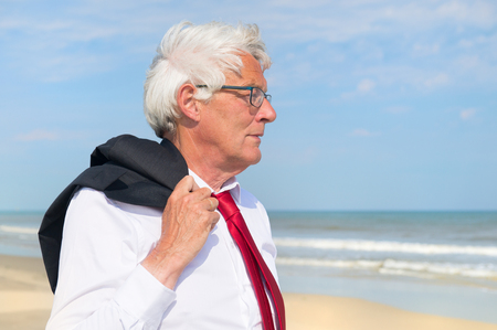 Business man in formal suit walking at the beachの写真素材