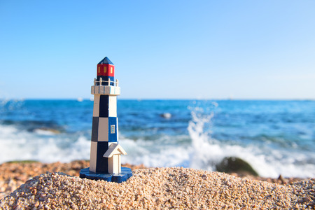 Miniature light house at the beach in front of the seaの写真素材