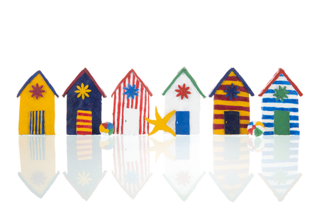 Row colorful handmade beach cabins isolated over whiteの写真素材