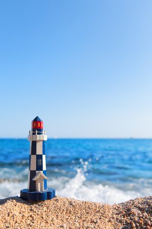 Miniature light house at the beach in front of the seaの写真素材