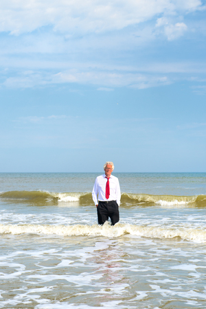 Business man in formal suit standing in the seaの写真素材