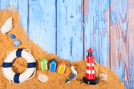 Beach poster on wooden background with cabines life buoy and lighthouseの写真素材