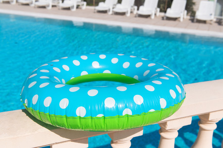 Floating ring toy in blue and green with swimming poolの写真素材