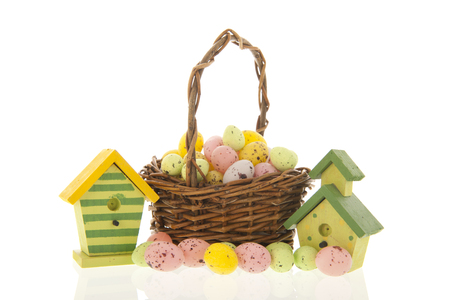 Easter eggs in basket with nest boxes for the birds isolated over whiteの写真素材
