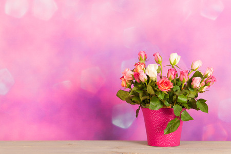Bouquet colorful roses in vase in pink living roomの写真素材
