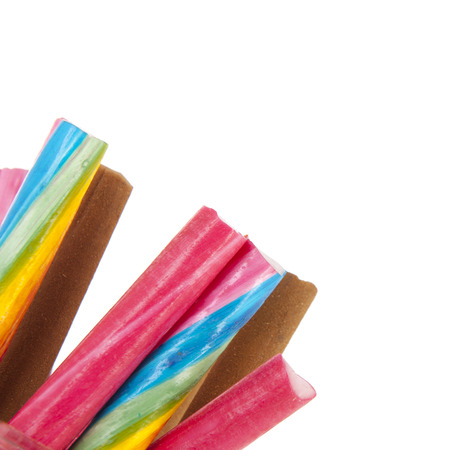 Glass pot of colorful candy canes isolated over whiteの写真素材