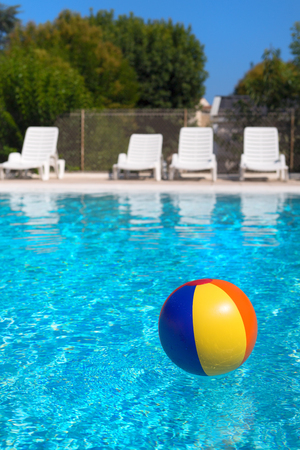 Inflatable colorful beach ball floating in waterの写真素材