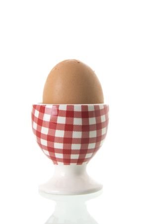 Chicken egg in red and white checkered cupの写真素材