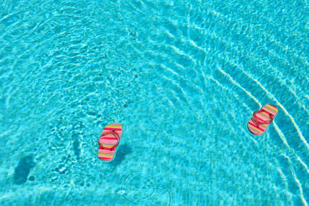 Colorful striped flip flops at the swimming pool