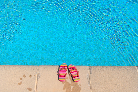Colorful striped flip flops at the swimming poolの写真素材