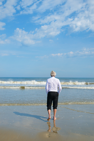 Business man in formal suit walking in the seaの写真素材
